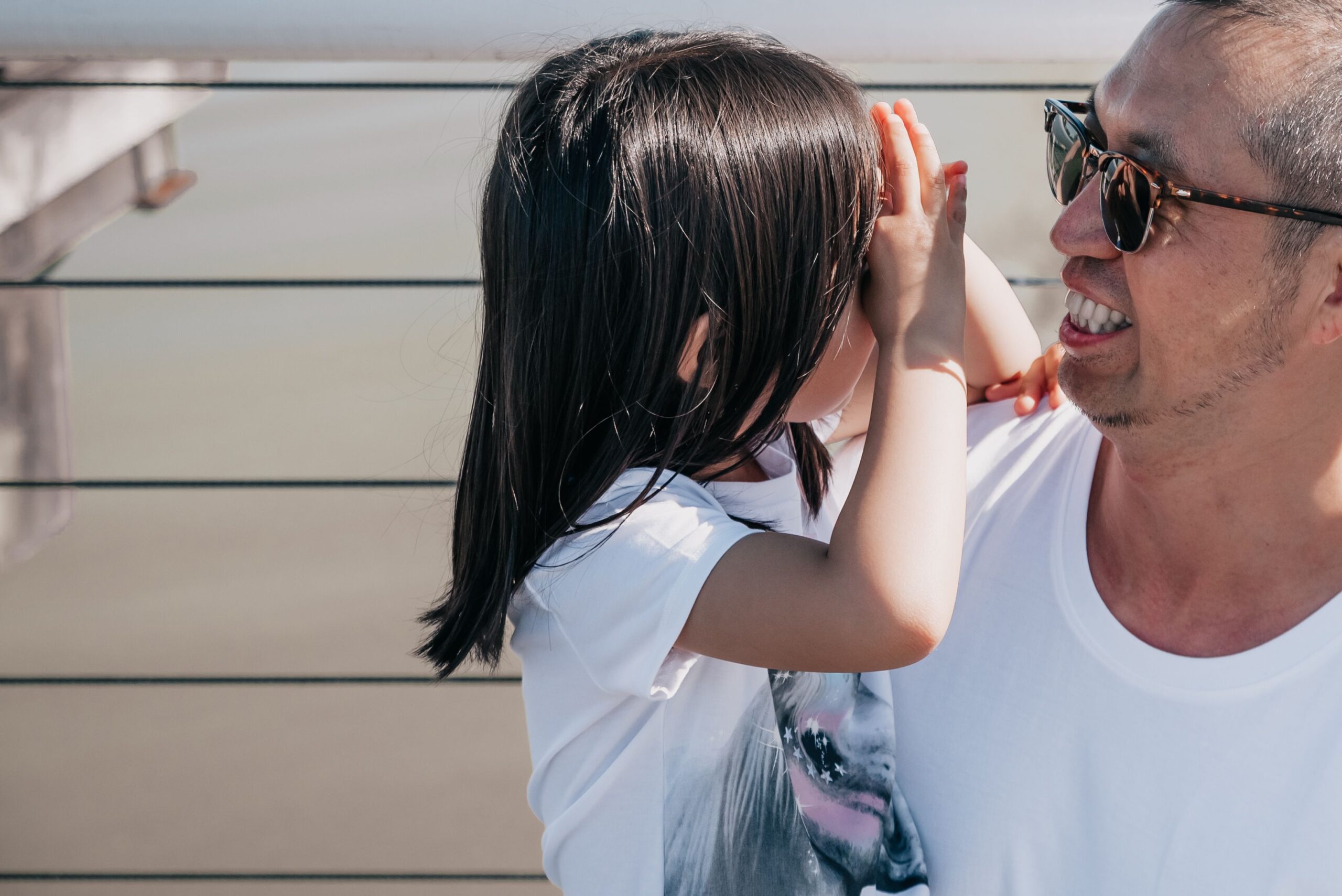 A candid shot of a father and daughter enjoying quality time outdoors, filled with joy and bonding.